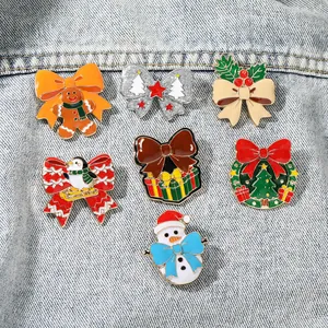 Dettaglio di un set di sette spille natalizie in smalto con Babbo Natale su tessuto denim