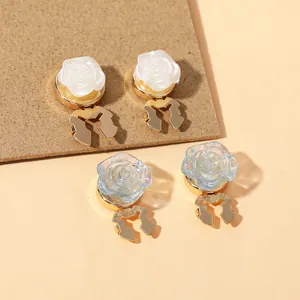 Close-up of elegant rose resin clips with gold metallic hollow bases in blue and white