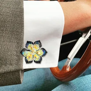 Floral crystal cufflinks with colorful iridescent petals on a white formal shirt cuff