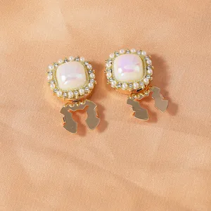 Detailed close-up of vintage gold cufflinks featuring iridescent stones and pearl borders