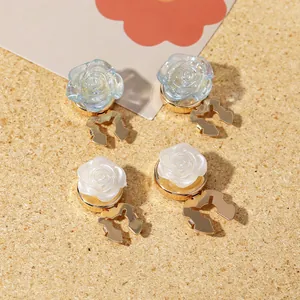 Elegant magnetic rose brooch pins in pearl white and iridescent blue on golden base