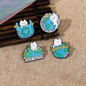 Détail de quatre pins en émail chat écolo avec strass sur un fond textile tissé