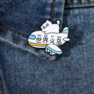 Close-up of a cute cartoon cat on a white airplane enamel pin on denim fabric