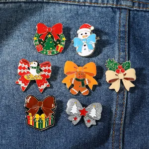Dettaglio di spille natalizie in smalto con Babbo Natale e pupazzo di neve su denim