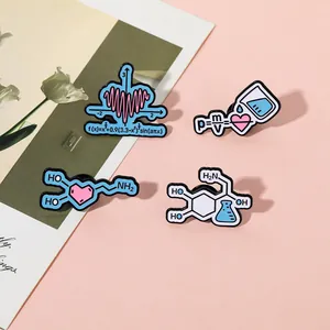 Detail of four creative science enamel pins featuring math and physics formulas on pink card
