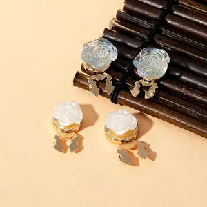 Detail view of pearlescent white and gradient blue rose clips with gold metal base