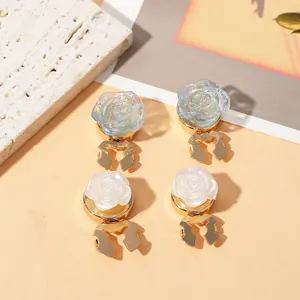 Detailed macro view of 3D rose-shaped shirt clips in iridescent blue and pearly white finish