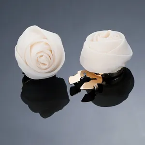 Makro-Detail von cremeweißen Mesh-Rosen-Ohrringen mit goldenem Clip-Verschluss