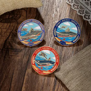 Detailed close-up of three metal aircraft carrier badges on a rustic wooden surface