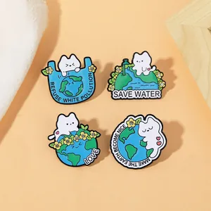 Détail de quatre pins chat en émail avec strass et slogans écolos sur tissu doux