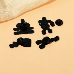 Back view of four black metal enamel pins with butterfly clasps on orange background