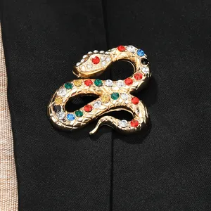 Dettaglio di una spilla a forma di serpente dorata con strass colorati su una giacca nera