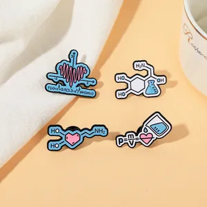 Detailed close-up of four science-themed metal enamel pins with physics and math formulas