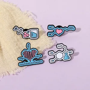 Macro view of four colorful science-themed enamel pins with physics and math formulas