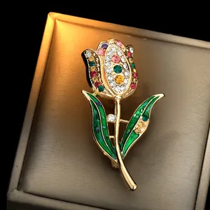 Elegante broche de tulipán con pedrería de colores y esmalte verde sobre base dorada