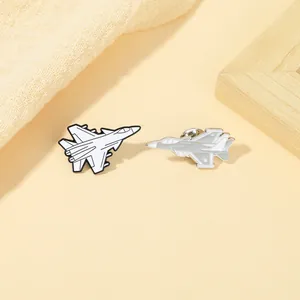 Detailed macro of enamel fighter jet brooches in white and grey aviation metal finishes