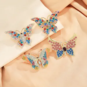 Close-up of elegant butterfly brooches with colorful rhinestones on champagne satin