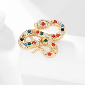 Dettaglio ravvicinato della spilla a serpente dorata con strass multicolore e trama squamata