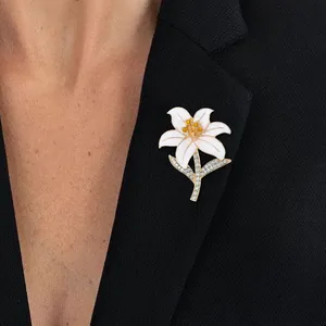 Elegant lily flower brooch with white enamel petals and crystals on a black suit jacket