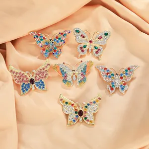Close-up of butterfly brooch set with colorful rhinestones on silk fabric