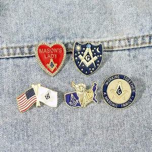 Detailed close-up of five enamel Masonic pins with gold edges on denim fabric