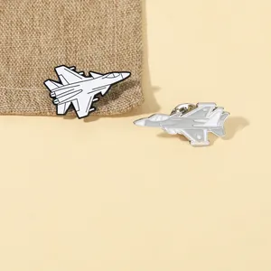 Detailed view of metal fighter jet enamel pins in black, white, and grey colors