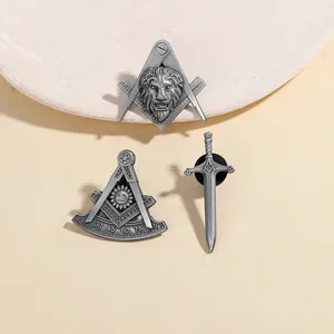 Set of 3 vintage Freemasonry metal brooches with lion and sword on stone tray