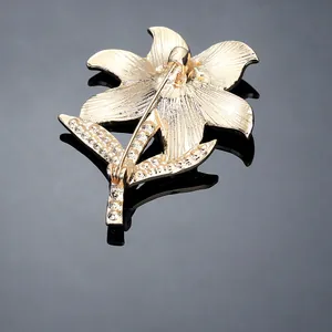 Elegant gold flower brooch with detailed back pin closure and brushed metal texture