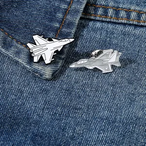 Close-up of airplane enamel pins on denim collar showing fine metal details