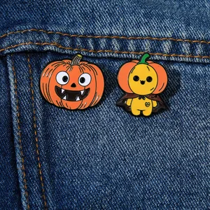 Set of two Halloween enamel pins with pumpkin and ghost motifs on blue denim fabric