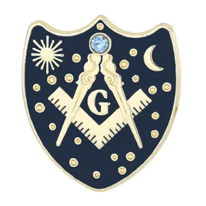 Macro detail of Masonic shield pin with G compass symbol and blue gemstone inlay