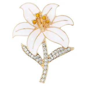 Elegant lily flower brooch with white enamel petals and gold plating on white background
