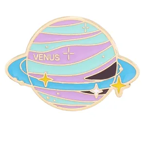 Dettaglio della spilla smaltata pianeta Venus in colori pastello e bordi dorati