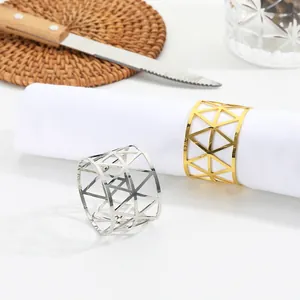 Detailed close-up of hollow geometric triangle napkin rings in gold and silver finish