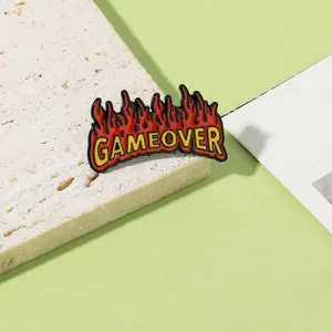 Detalle del pin de esmalte Game Over con llamas rojas sobre una base de piedra natural