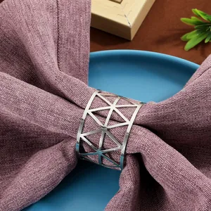 Detail of silver geometric mesh napkin ring on a purple linen cloth for table decor