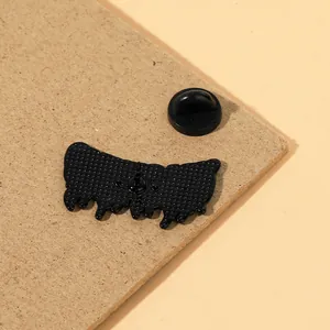 Detalle del reverso del pin metálico con cierre de goma negra y textura de aleación