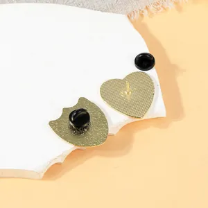 Macro detail of alloy lapel pins showing the gold-plated textured back and rubber clutch
