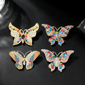 Detail of four butterfly brooches with colorful rhinestones on a dark textured background