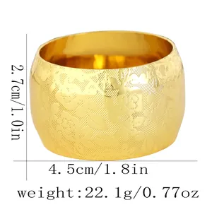 Macro detail of gold napkin ring with floral relief and size dimensions in centimeters