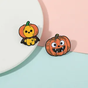 Dettaglio di due spille in smalto di Halloween con zucca e una figura gialla di cartone