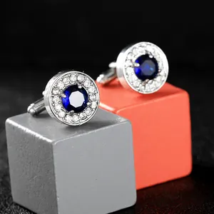 Macro shot of silver cufflinks with deep blue sapphire zircon and sparkling crystal halo
