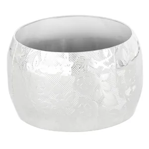 Close-up of a silver drum napkin ring featuring embossed floral patterns and metal texture