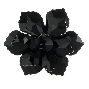 Macro view of a 3D crystal flower button with multifaceted black petals and glossy finish