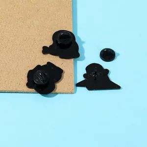 Vista posteriore dettagliata delle spille pinguino con chiusure in gomma nera e aghi fini