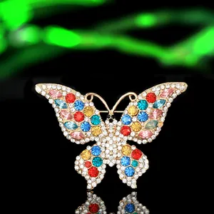 Macro view of butterfly brooch with colorful rhinestones on polished gold alloy