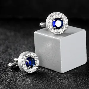 Formal silver cufflinks featuring large round blue zircon and halo of small white crystals