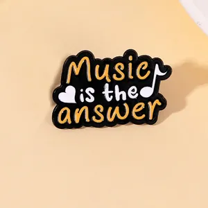 Detailed close-up of a black enamel music brooch with Music is the answer text