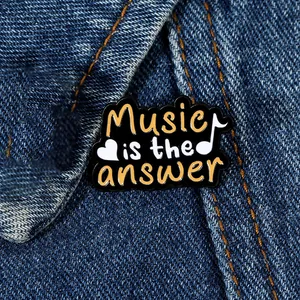 Close-up of Music is the answer enamel pin on denim jacket with heart and notes