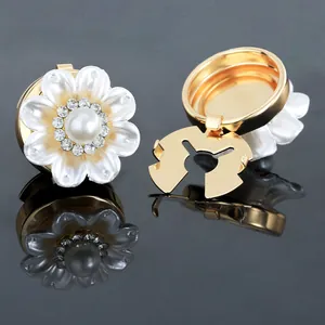 Macro view of gold flower cufflinks with pearl petals and sparkling rhinestone details